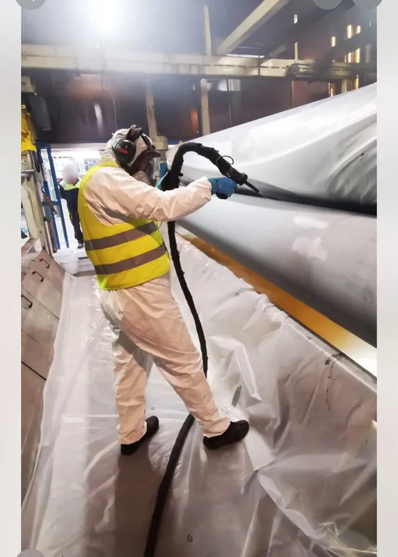 Medewerker in beschermende kleding reinigt een productielijn