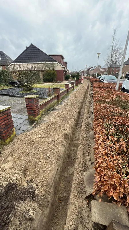 Lange sleuf langs een woonstraat